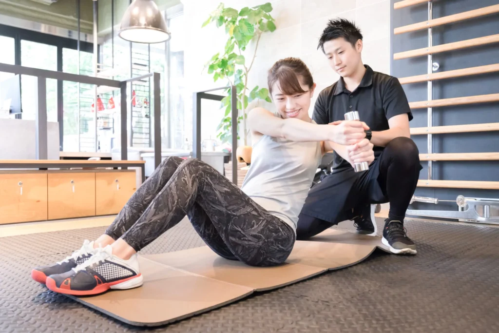 トレーニングの指導をする男性と、指導を受ける女性の写真
